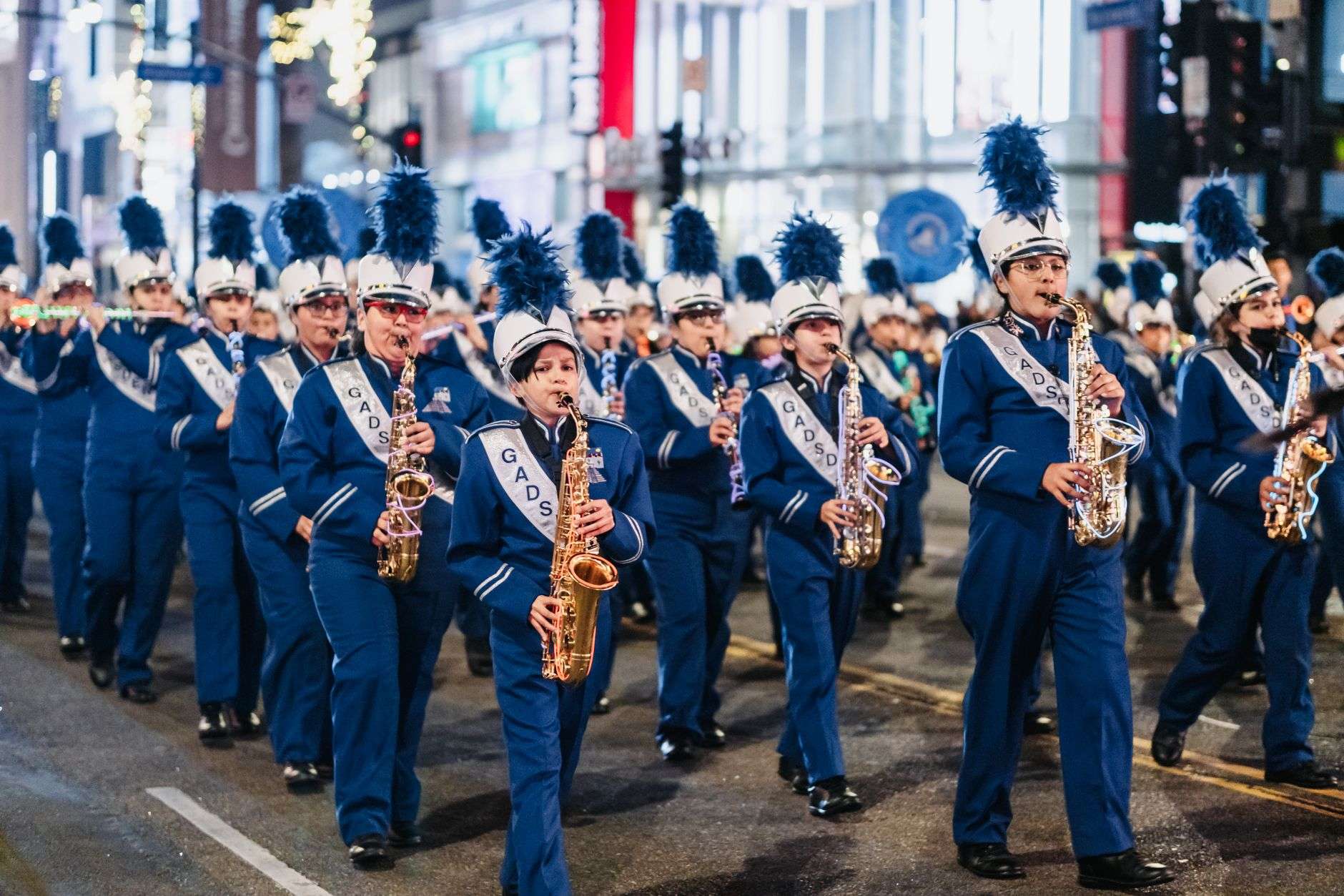School marching band performs during a community parade, similar to the Makos on Main event in Orange Beach