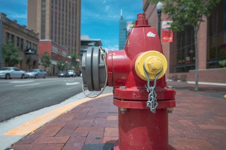 A red fire hydrant on a city street, representative of hydrant flushing done ahead of water line work