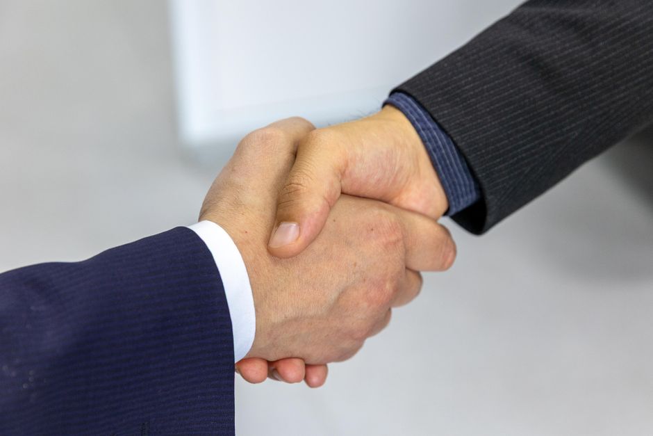 Business professionals shaking hands representing a company merger