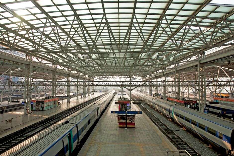 Passenger train platform at a railway station with tracks and overhead lighting