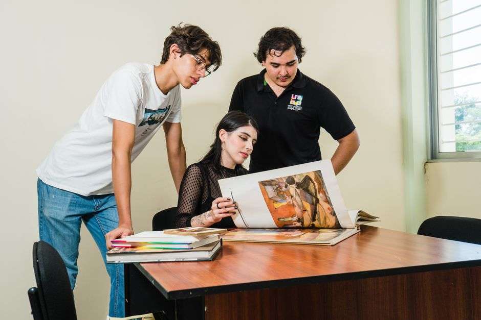 College art students and an instructor review artwork together in a studio classroom