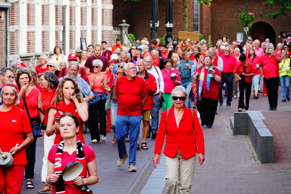 A community gathered for a public awareness procession near a waterfront pier