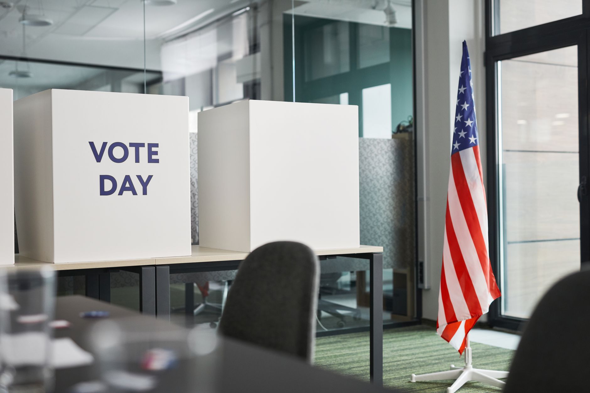 An American flag beside a polling place sign on Election Day