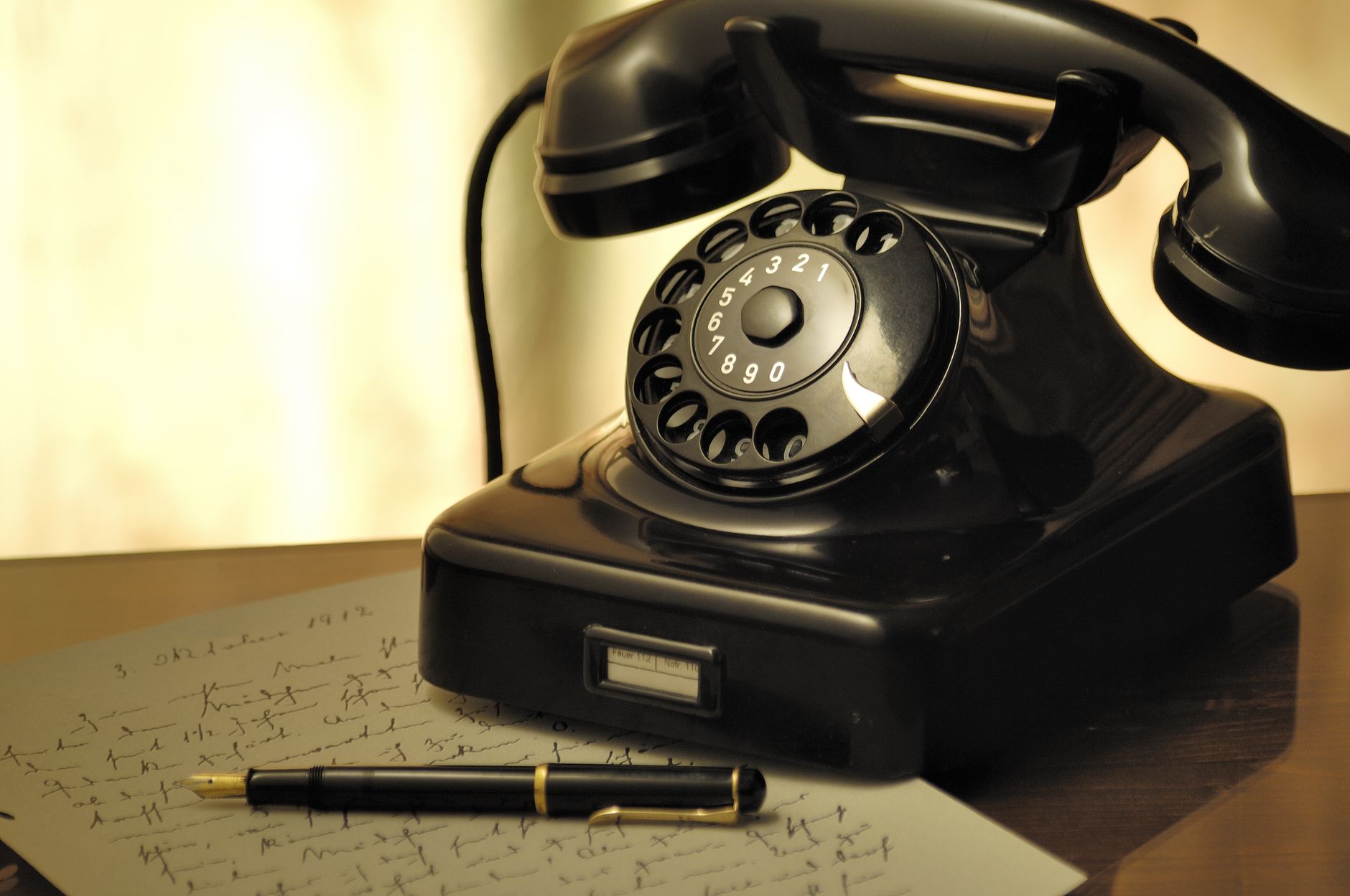 Vintage rotary telephone on a cluttered office desk