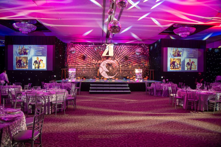 An elegantly decorated ballroom with garden-themed floral displays for a formal debutante ball
