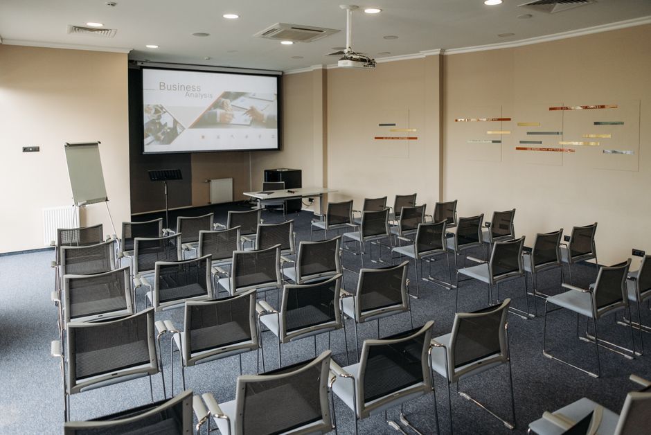 A business summit meeting room with attendees seated at tables