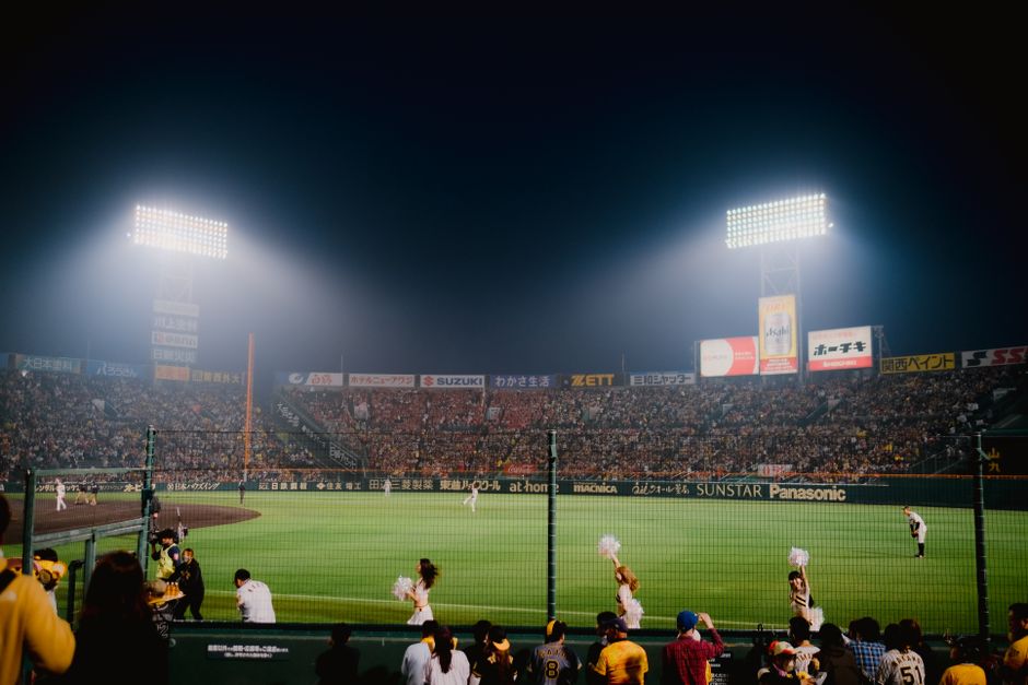 A baseball stadium with lighting at dusk