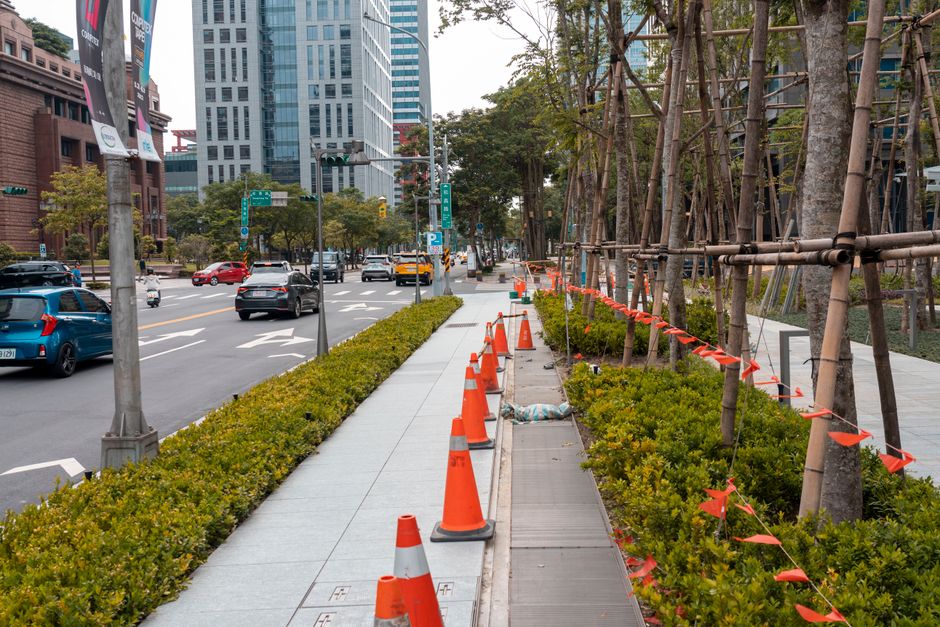Crew mowing a grassy roadside right-of-way in a city