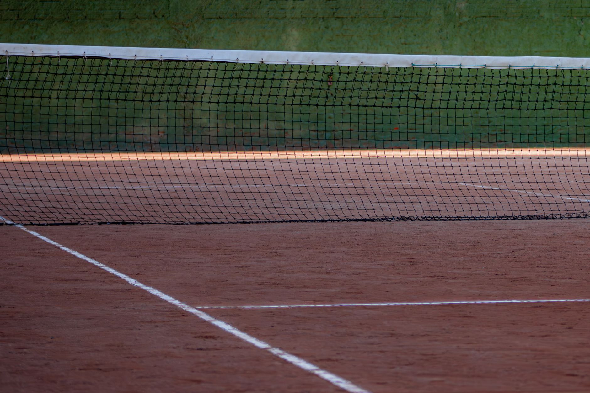 An empty tennis court with a net and racket