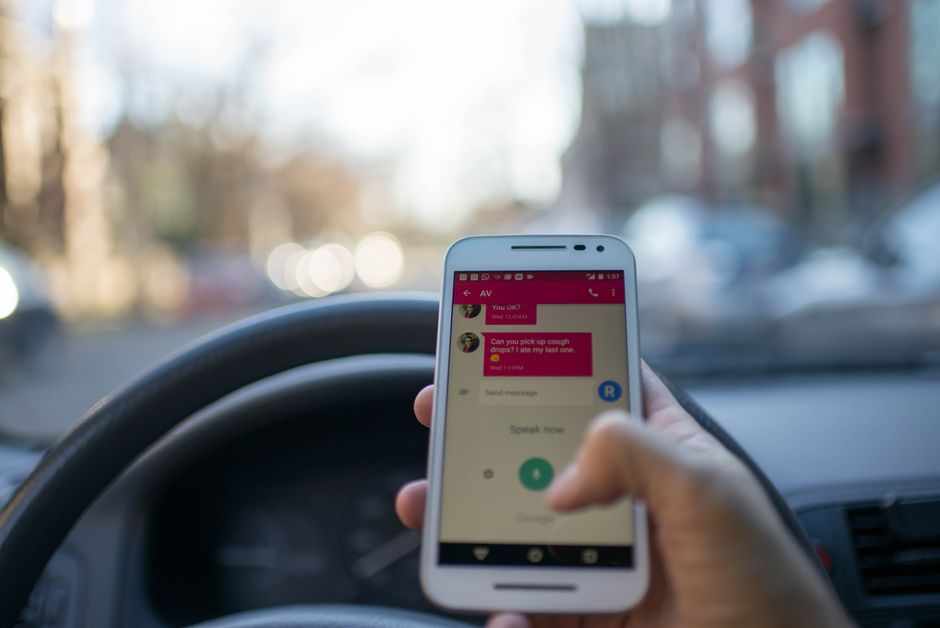 A young driver's hand near a phone, representing a teen distracted driving awareness campaign