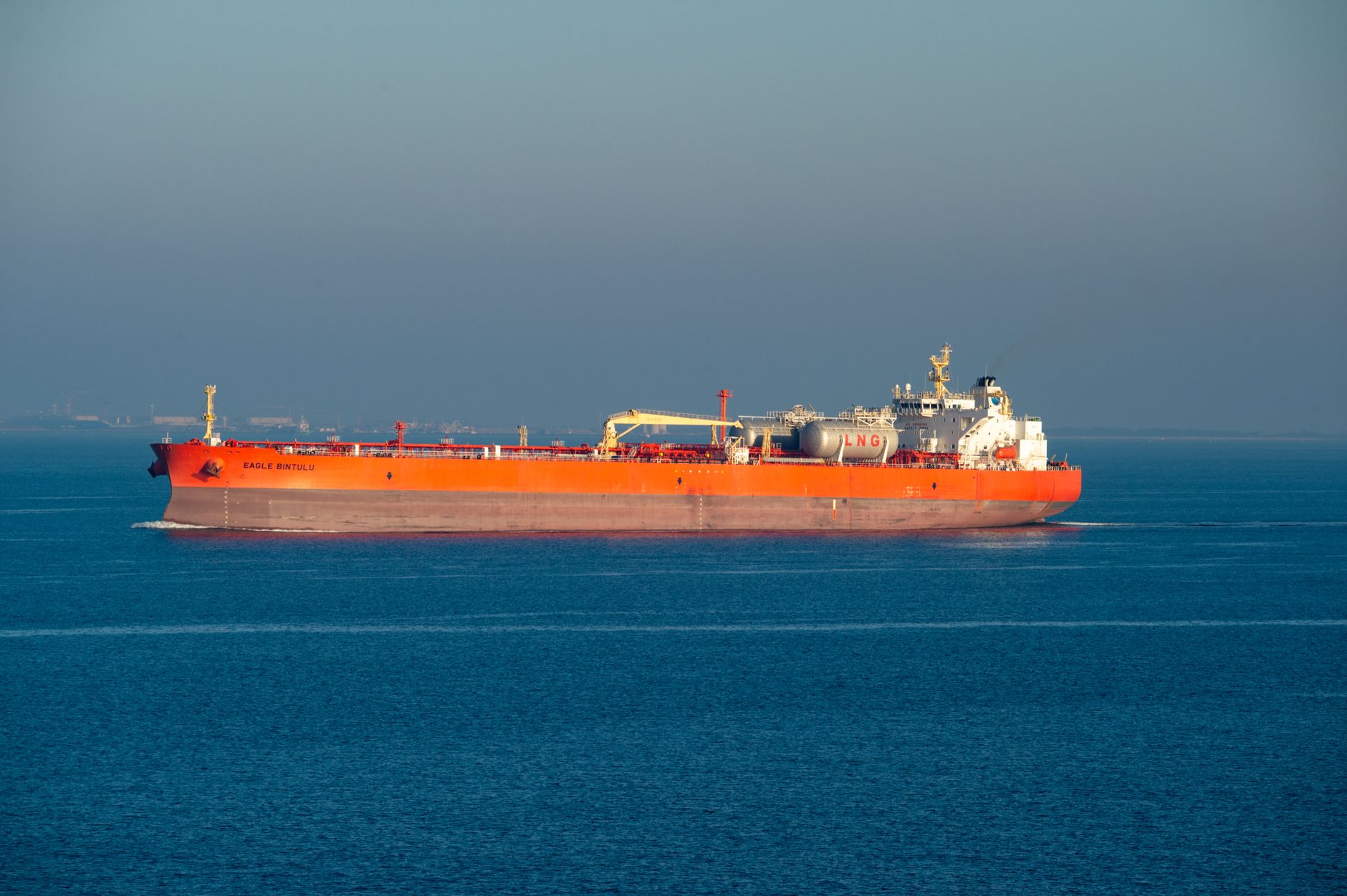 Liquefied natural gas storage tanks and marine terminal along a coastline