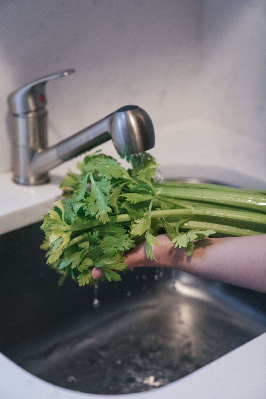 Fresh produce being rinsed under running water
