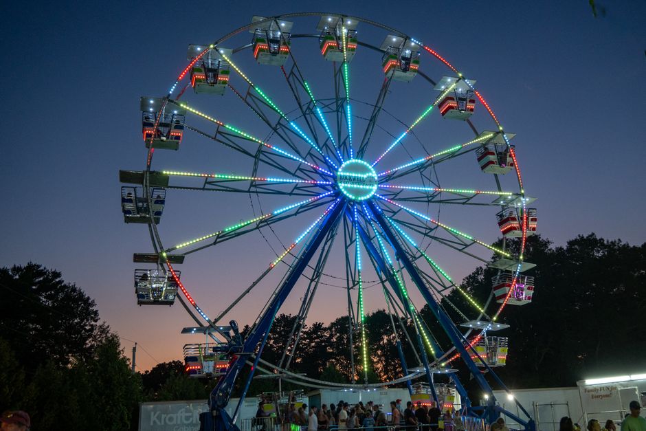 Fairgrounds ride lit up at night during a state fair