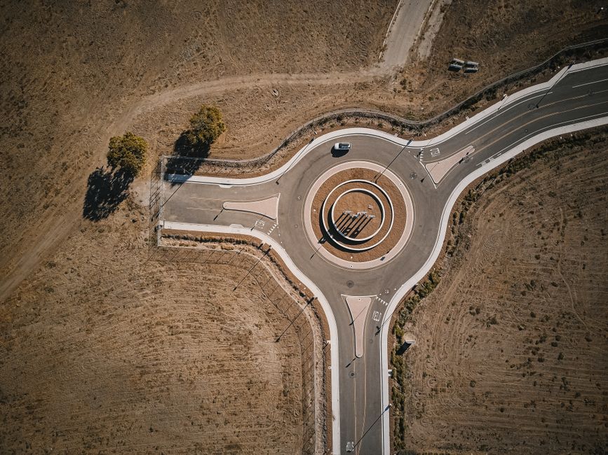 Construction equipment building a roundabout at a rural road intersection