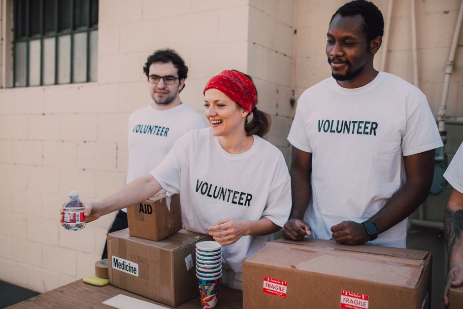Volunteers organizing a charity fundraiser table with donated items