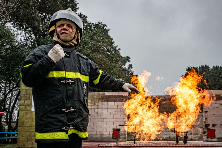 Firefighters in gear training at an academy