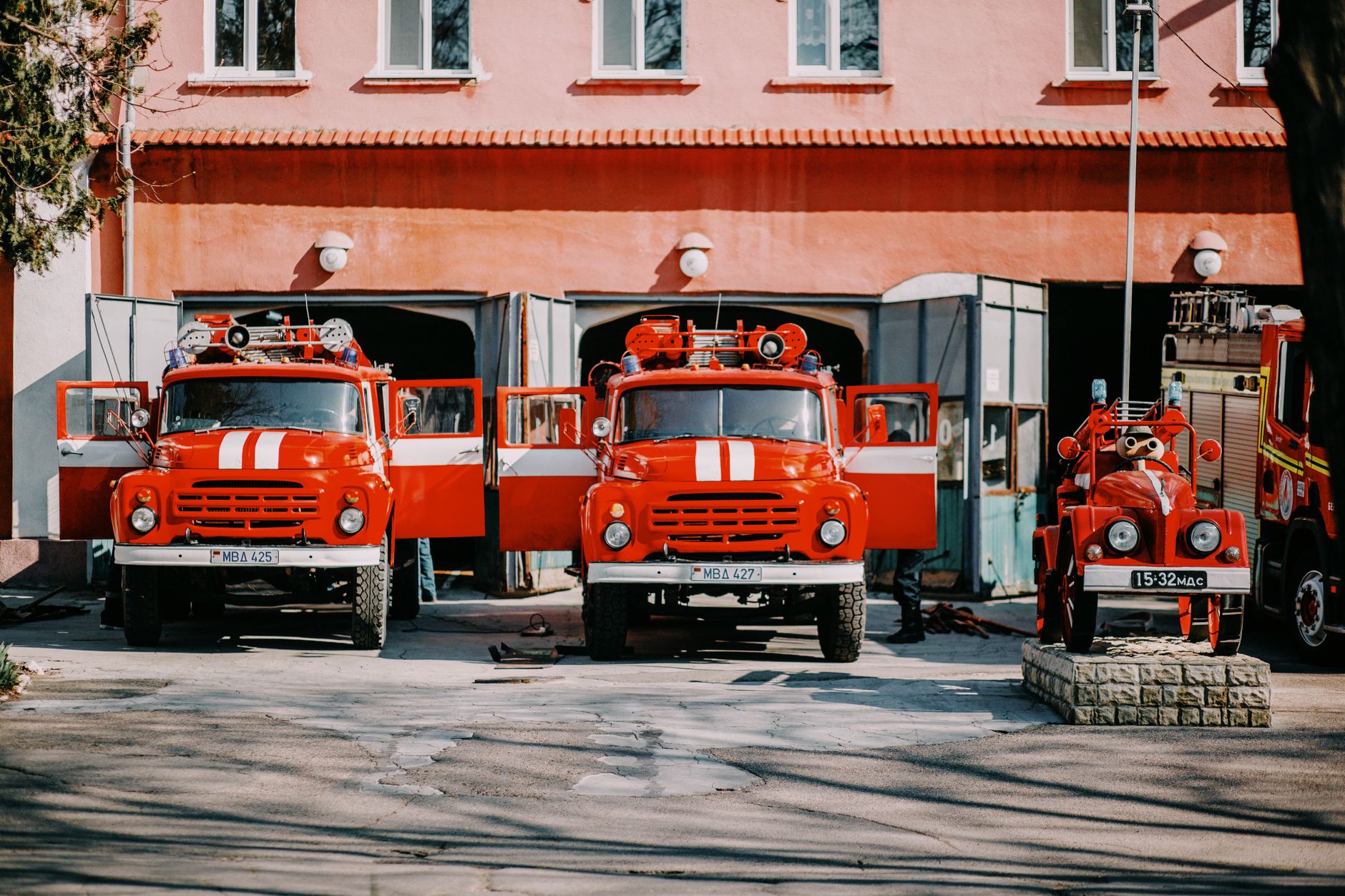 Firefighters standing beside a fire engine outside a station