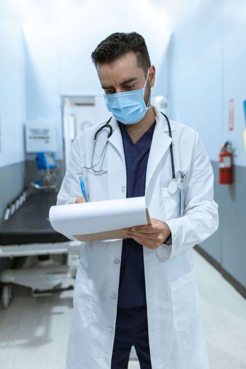 Medical worker wearing a face mask conducting a health screening