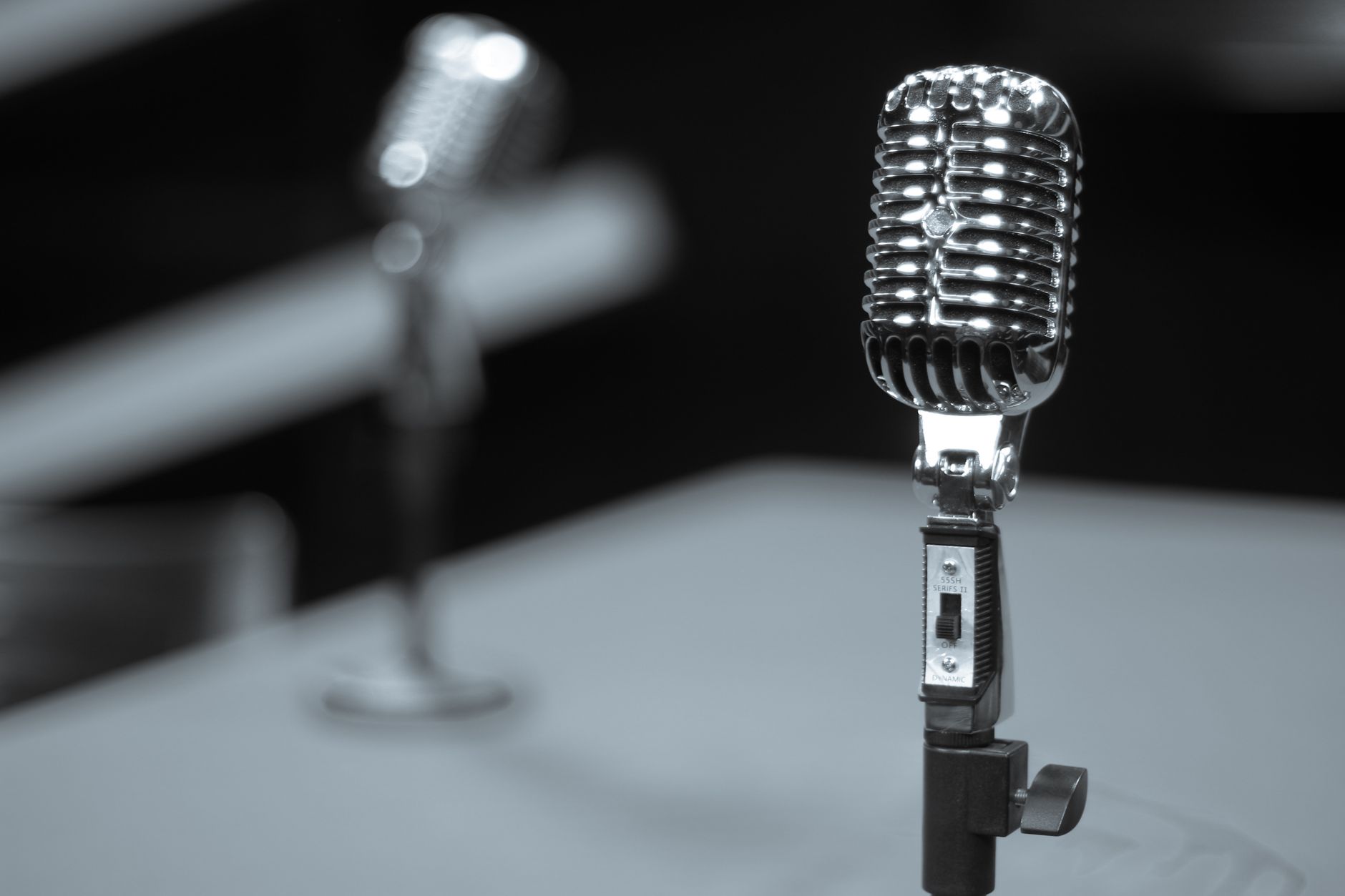 A vintage radio studio microphone with concert lighting in the background