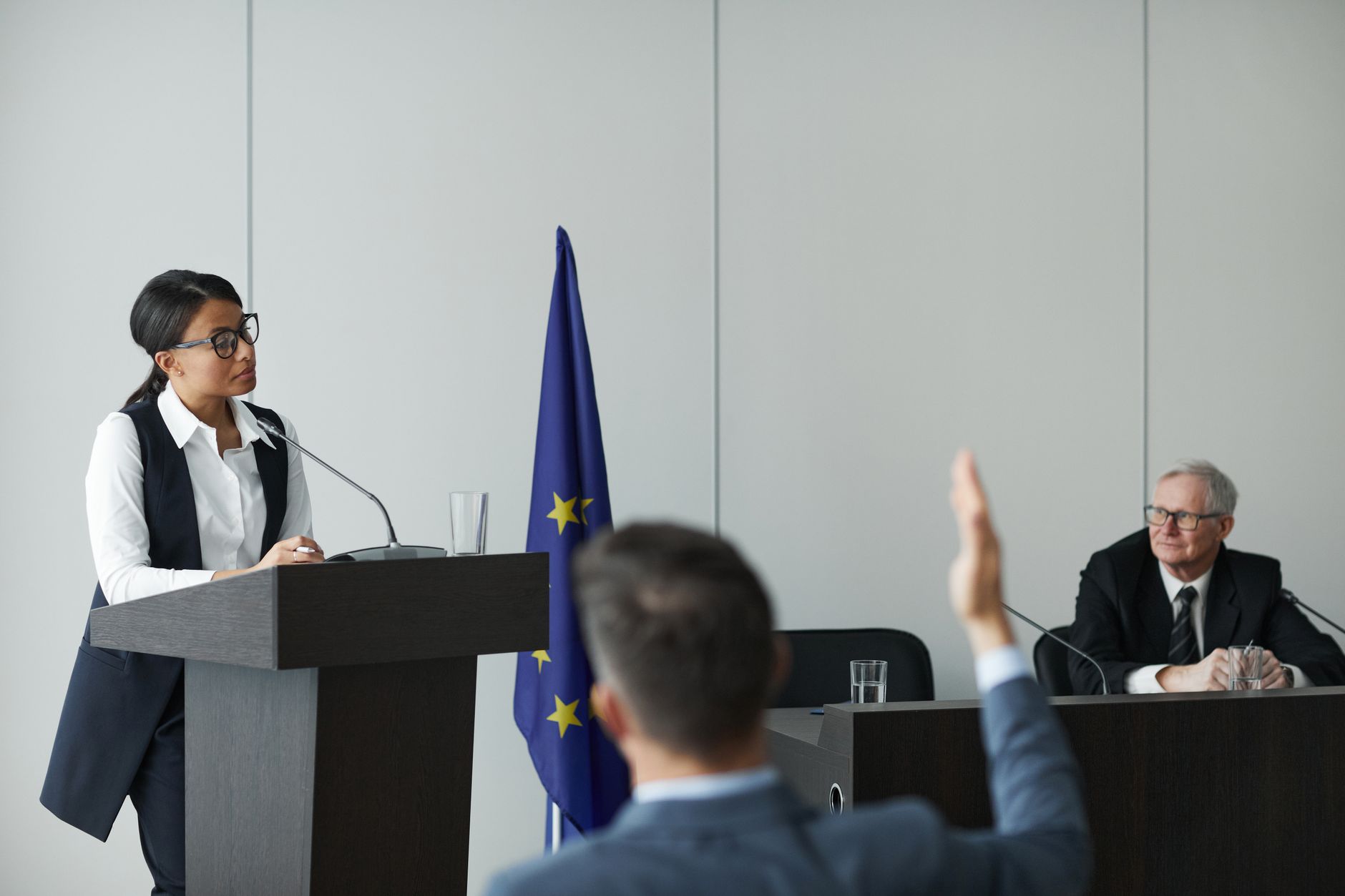 A speaker addressing a seated audience in a community hall