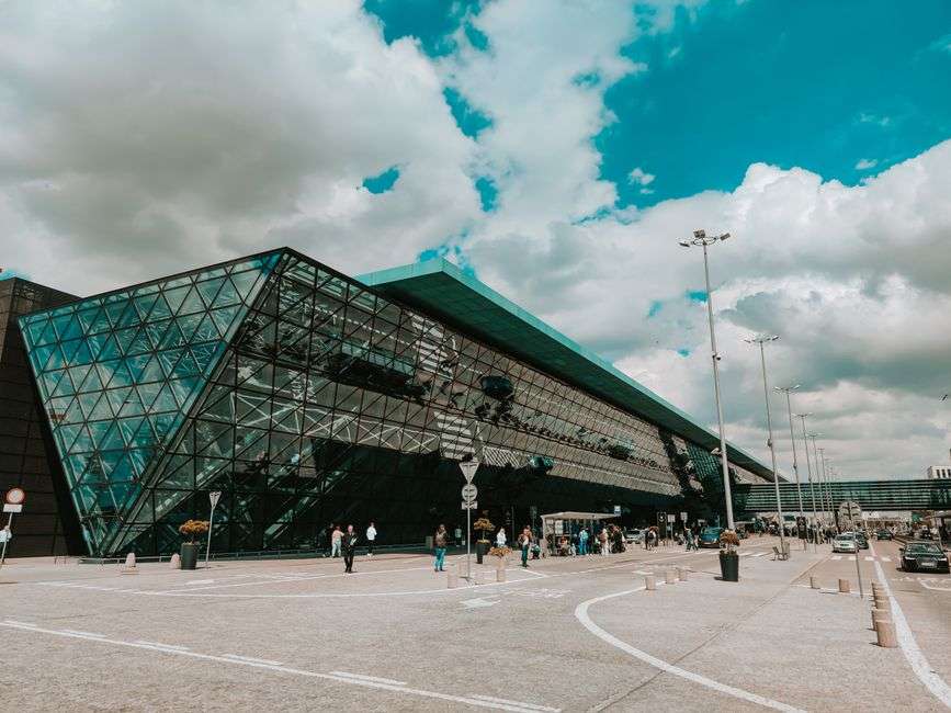 Modern airport terminal with a glass facade under a cloudy sky