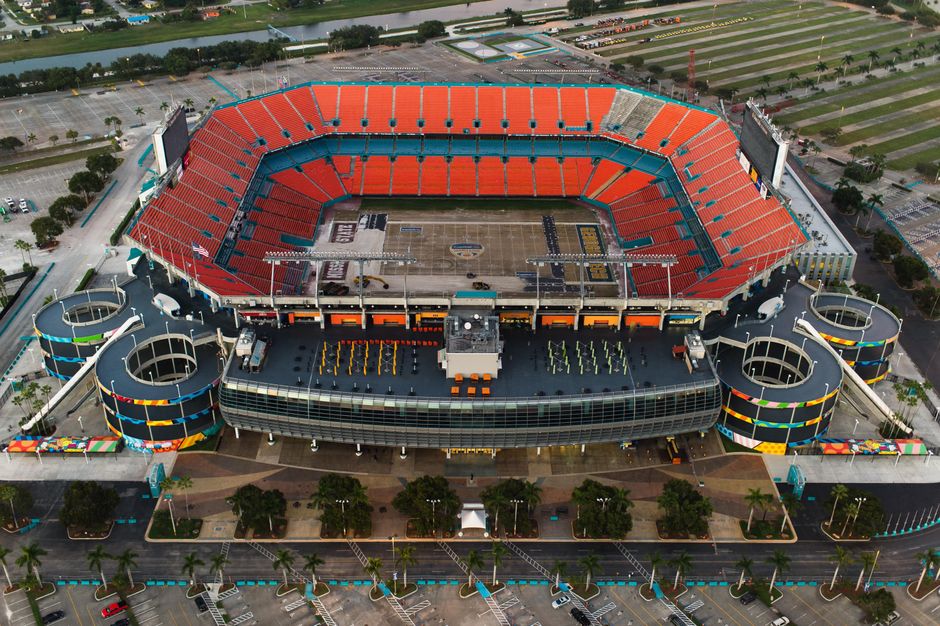 A crowd of fans tailgating in a stadium parking lot before a game