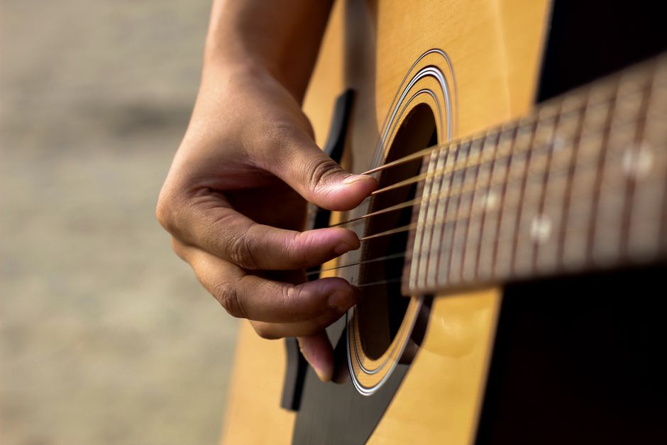 A musician playing an acoustic guitar during a live performance
