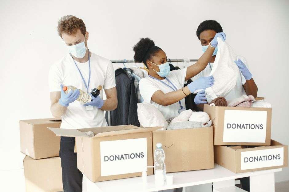 Volunteers pack donated protective masks and supplies into boxes for delivery to a local hospital