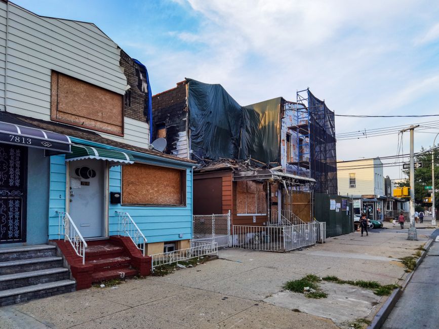 A boarded-up house on a city residential street