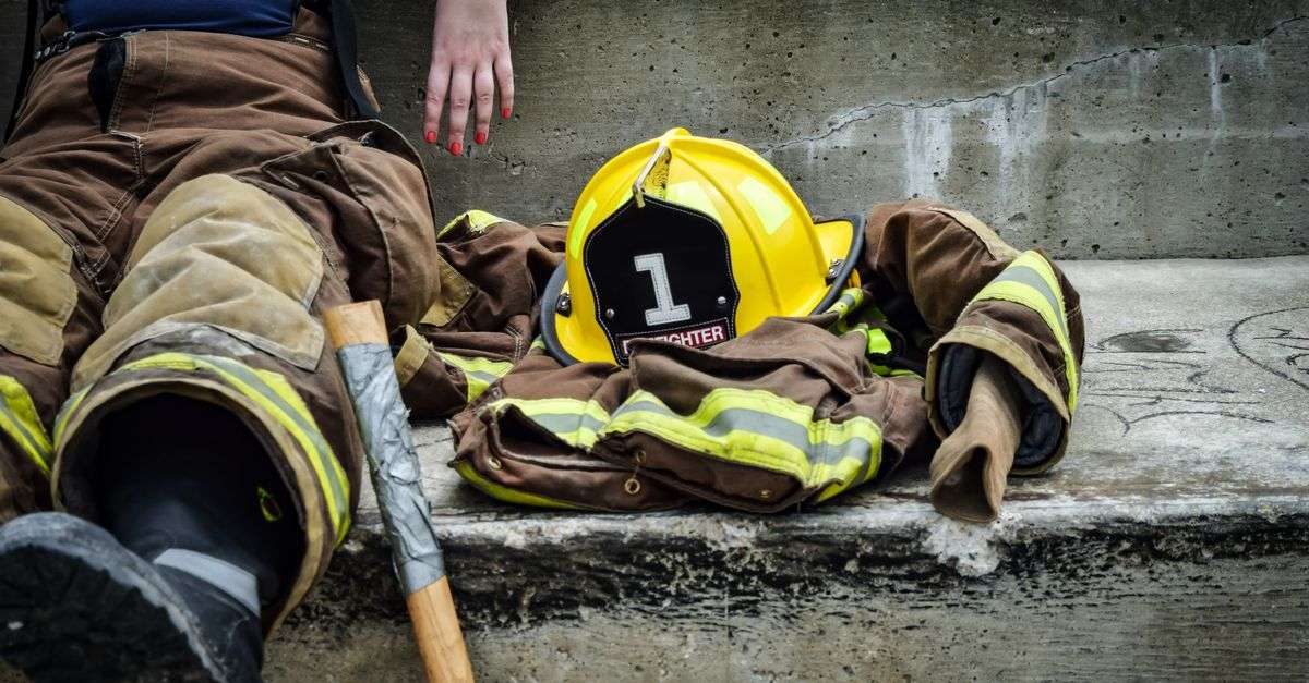 Retired firefighter sitting with helmet and gear, symbolizing Mobile police and fire retirees