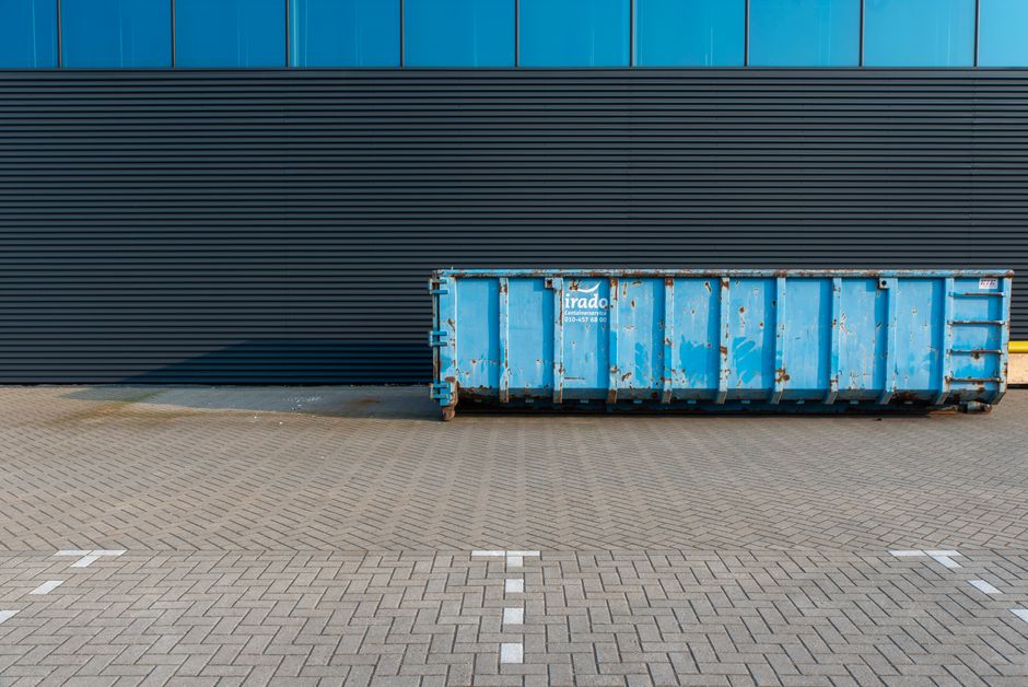 A commercial trash dumpster in a parking lot representative of Mobile's litter ordinance enforcement