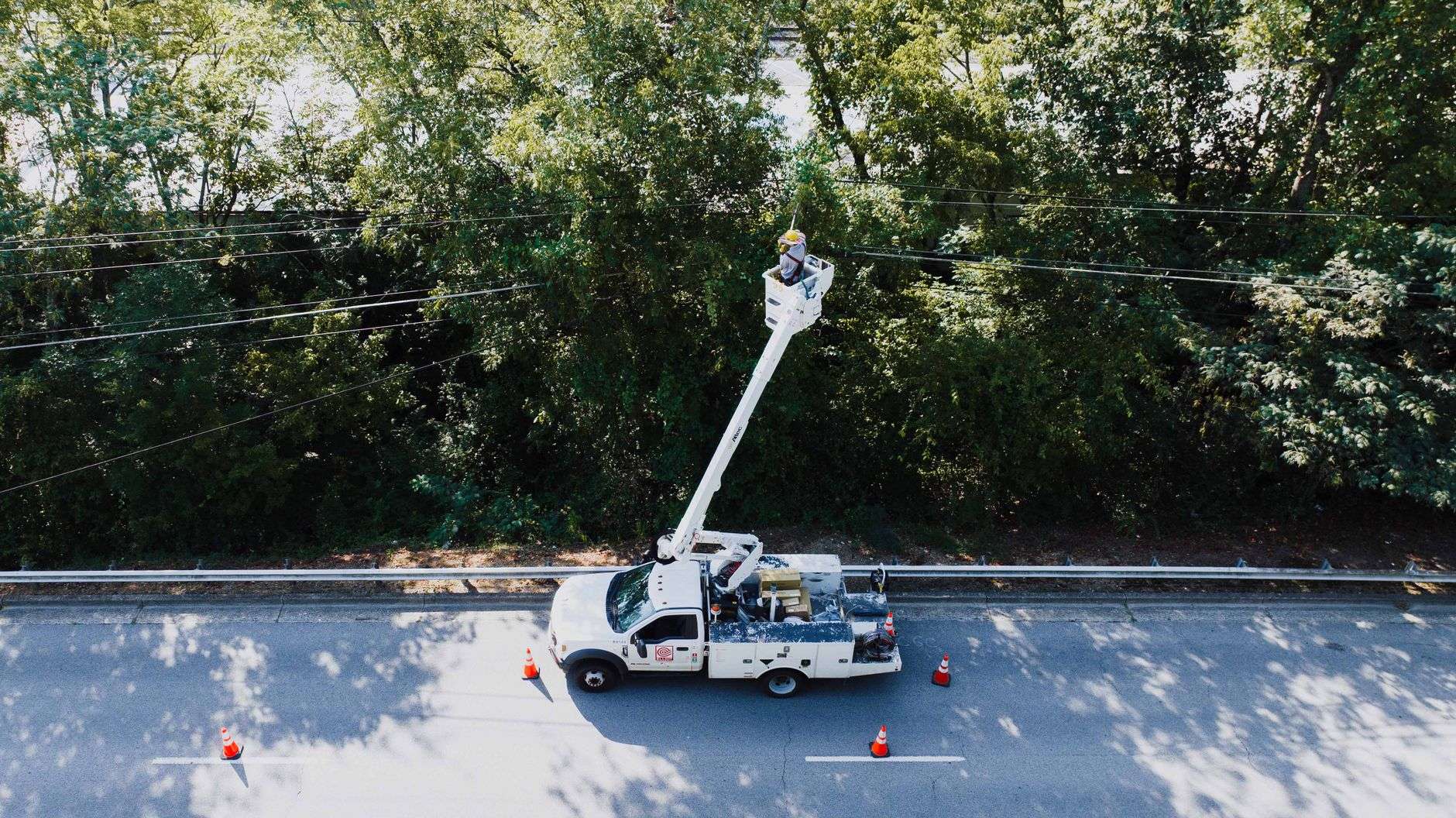 Utility worker on a bucket truck repairing power lines