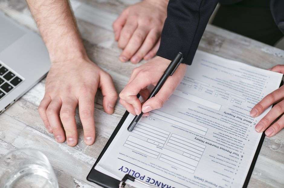 Close-up of a health insurance policy document being reviewed and signed