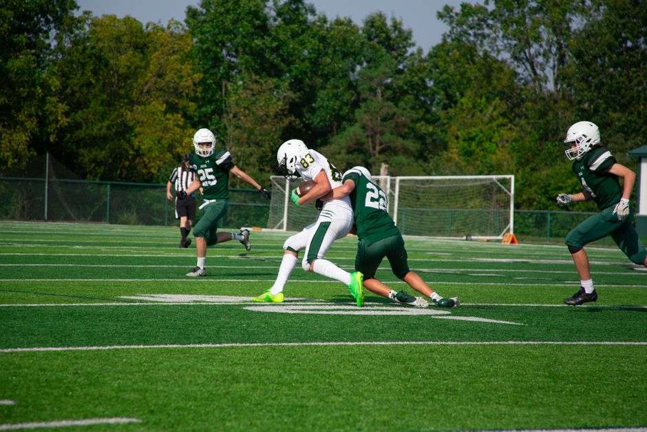 Football players compete in a hard-hitting tackle during a local semi-pro football game