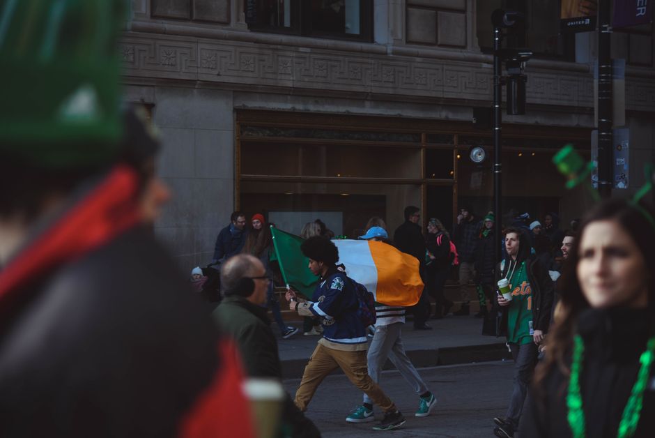 A St. Patrick's Day parade with green-clad crowds along a downtown street