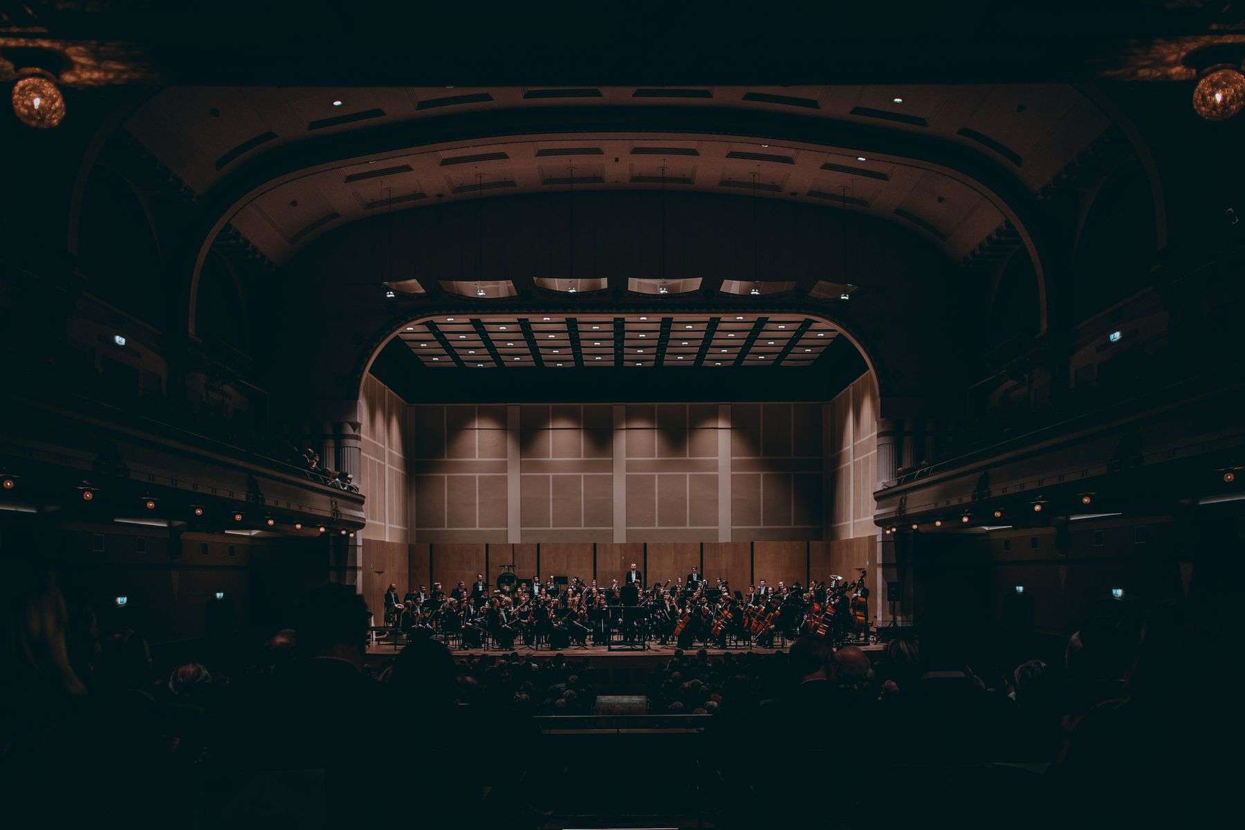 A full orchestra performing on a theater stage
