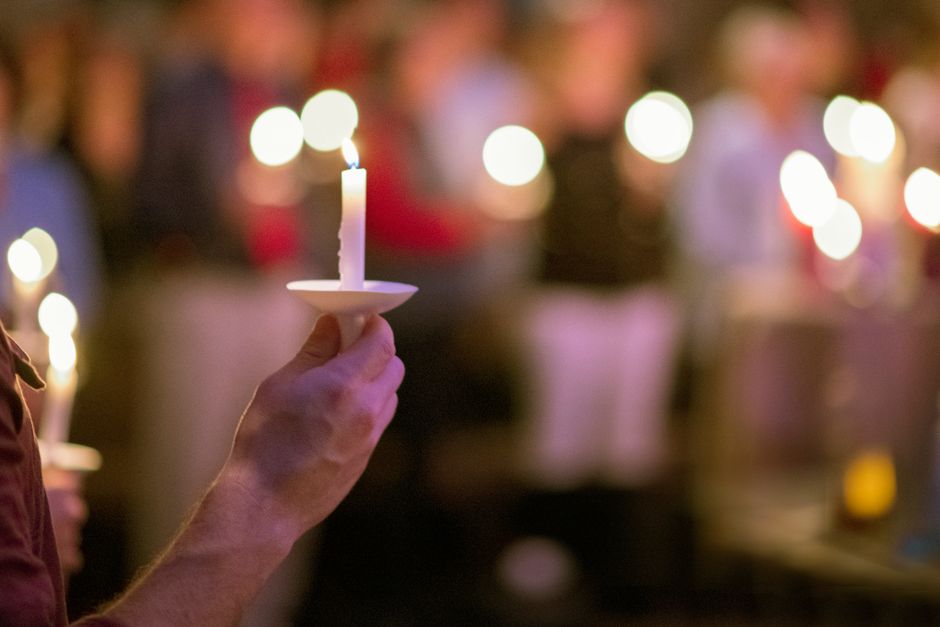 Candles at a memorial vigil representing community grief over a fatal shooting