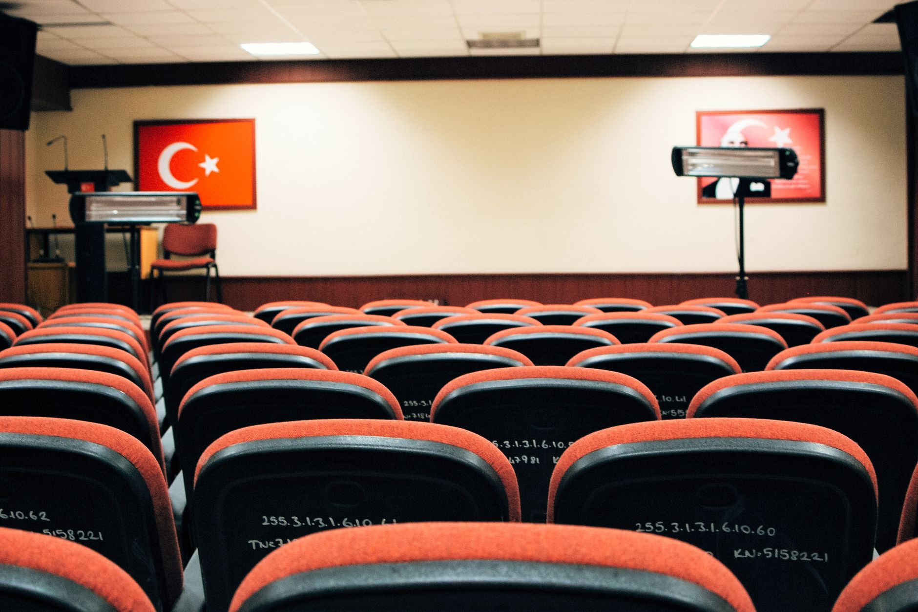 Rows of empty folding chairs in a campaign event hall