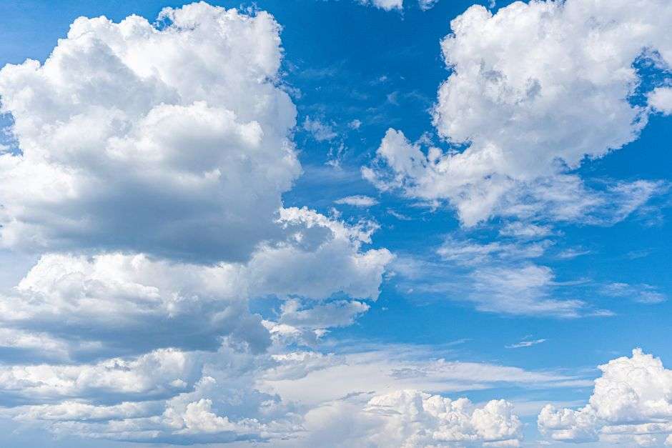 Puffy clouds fill a blue sky over the Gulf Coast