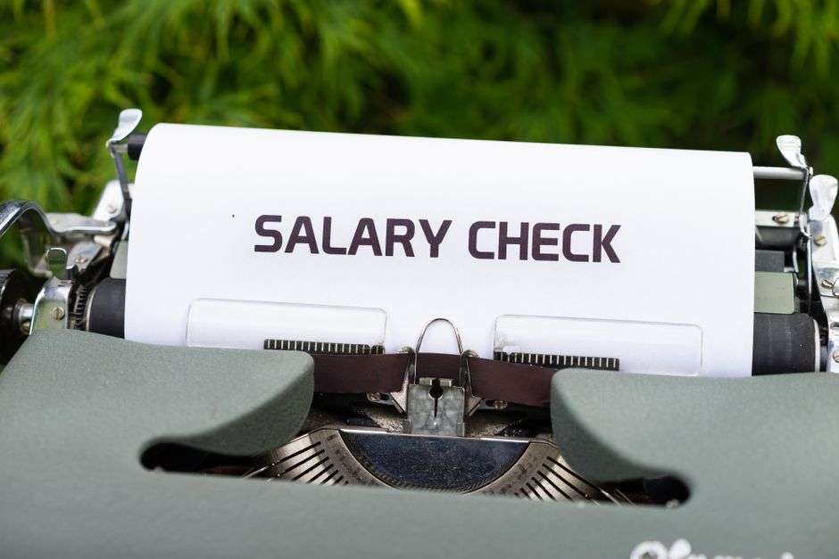 A handwritten salary check symbolizing wages and worker paychecks