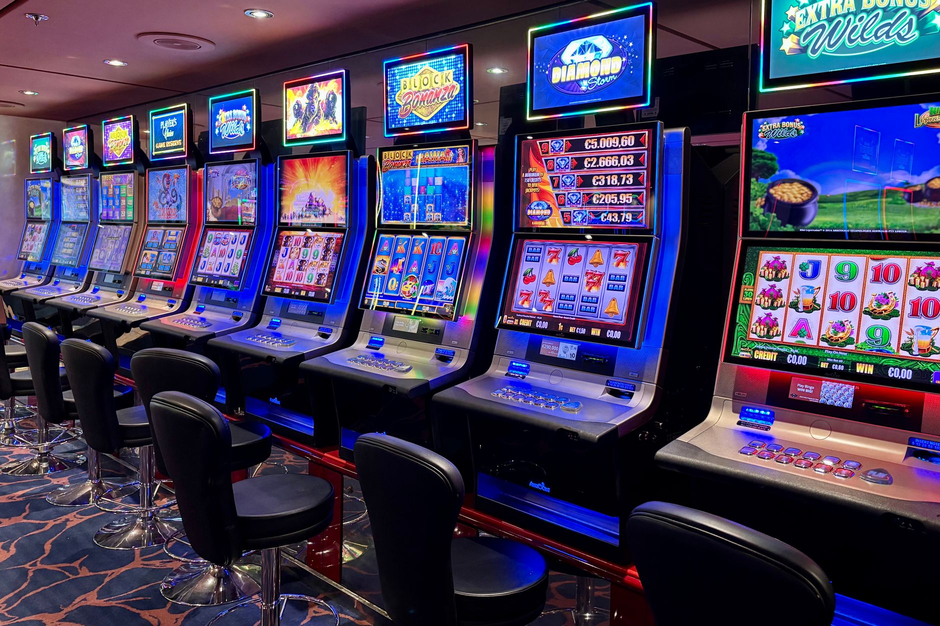 Row of electronic gambling machines with bright lights