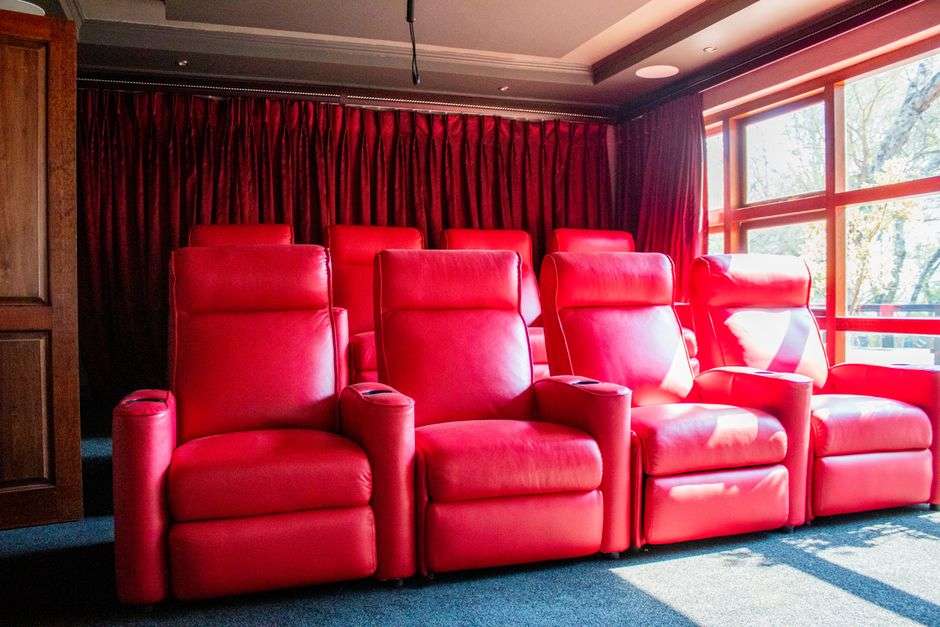 Red leather reclining theater seats in a dine-in movie theater