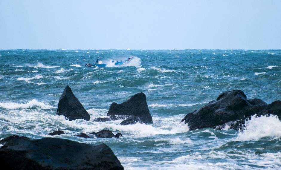 A charter fishing boat navigates rough, choppy seas along the Alabama Gulf Coast