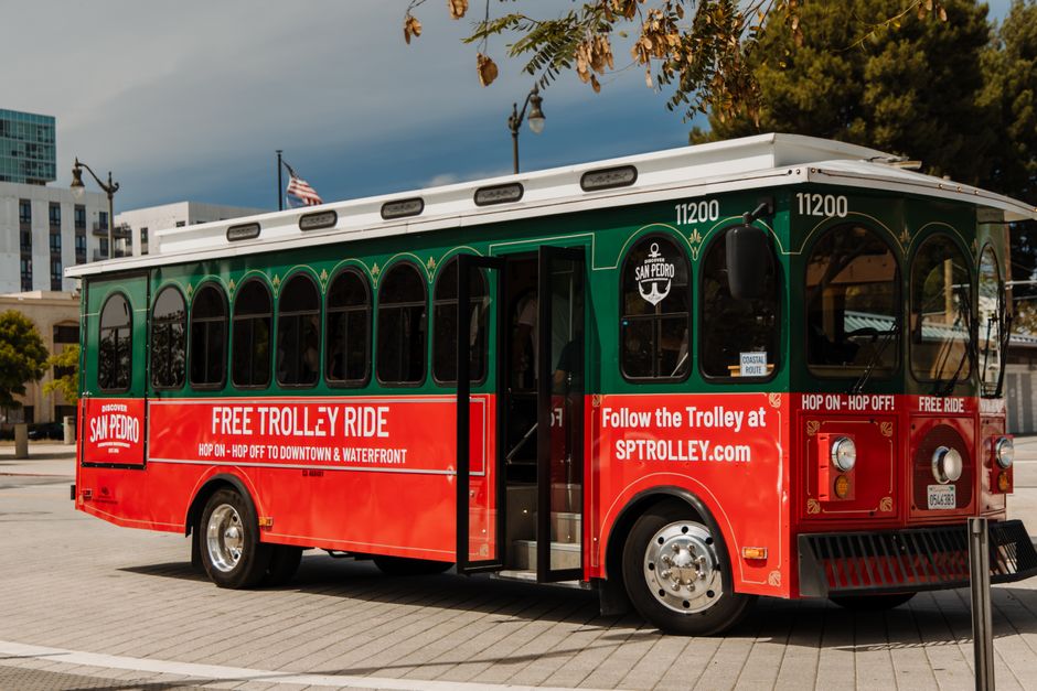 A small trolley-style bus parked near a beach road