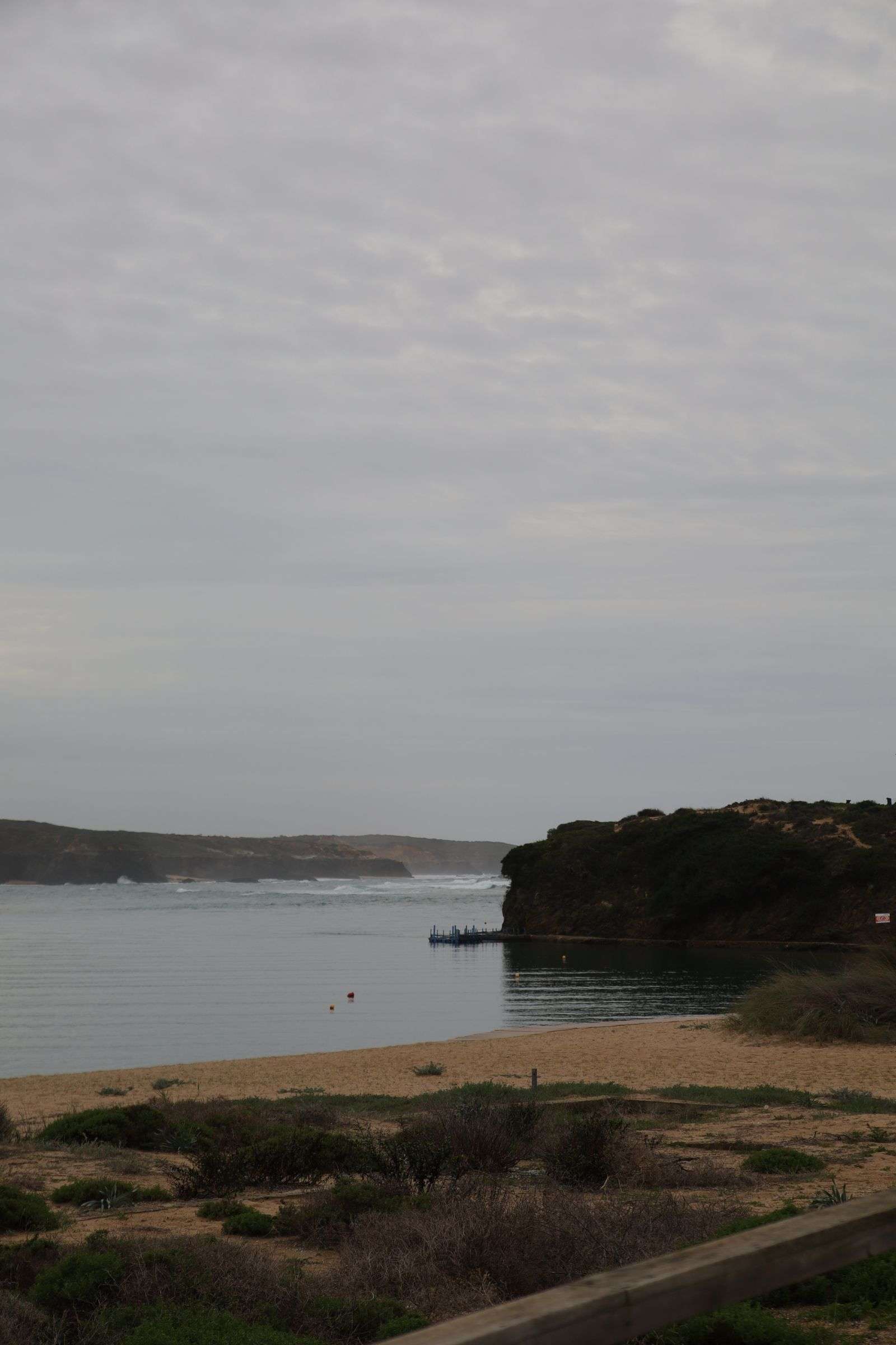 Calm coastal shoreline under an overcast sky