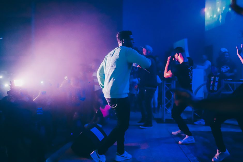 A hip-hop artist performing on stage at a nightclub