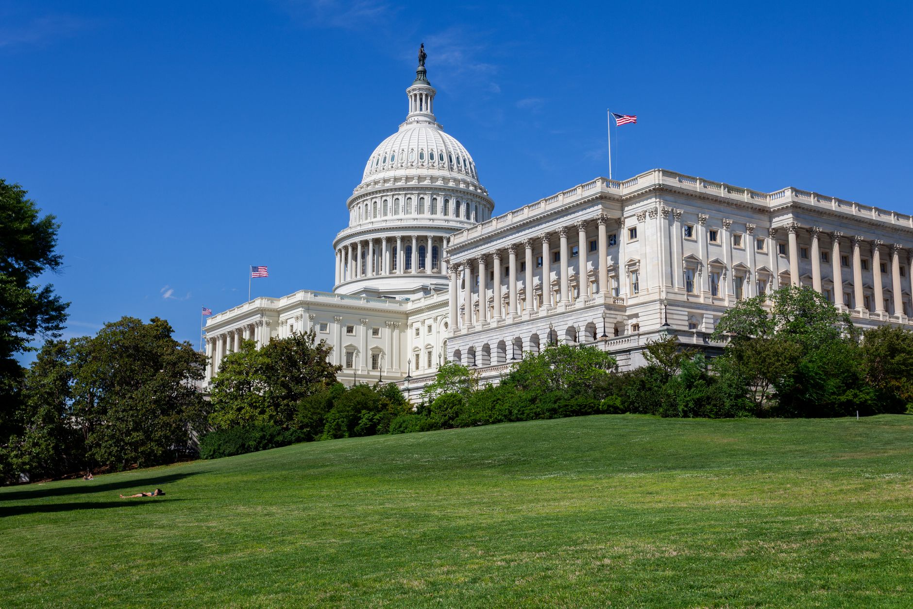 An American flag with the U.S. Capitol in the background