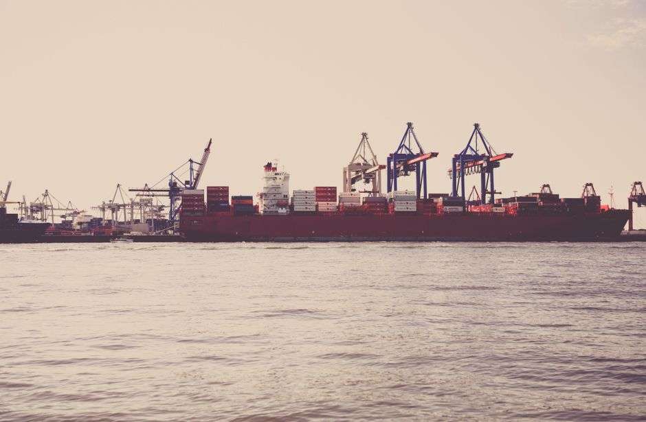 A commercial shipping port with cargo cranes and containers