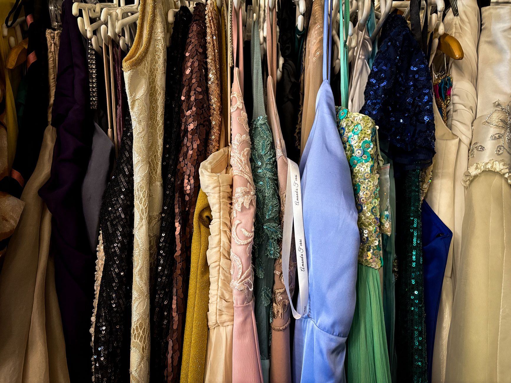 Rows of formal prom gowns hanging on a boutique rack