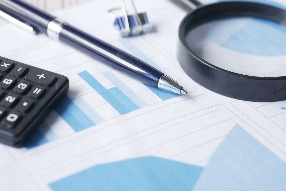 Financial documents, a calculator and a magnifying glass symbolizing a fraud audit